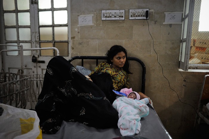 Sản phụ 19 tuổi đang nằm cạnh con mới sinh tại một bệnh viện ở Karachi, thành phố đông dân nhất ở Pakistan.